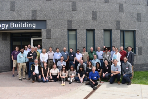 A group portrait of about thirty people in front of a building.