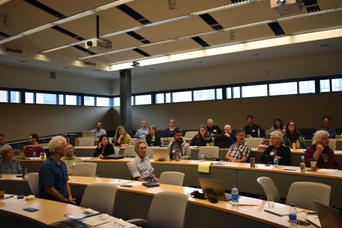 Conference participants having a discussion in a lecture hall.