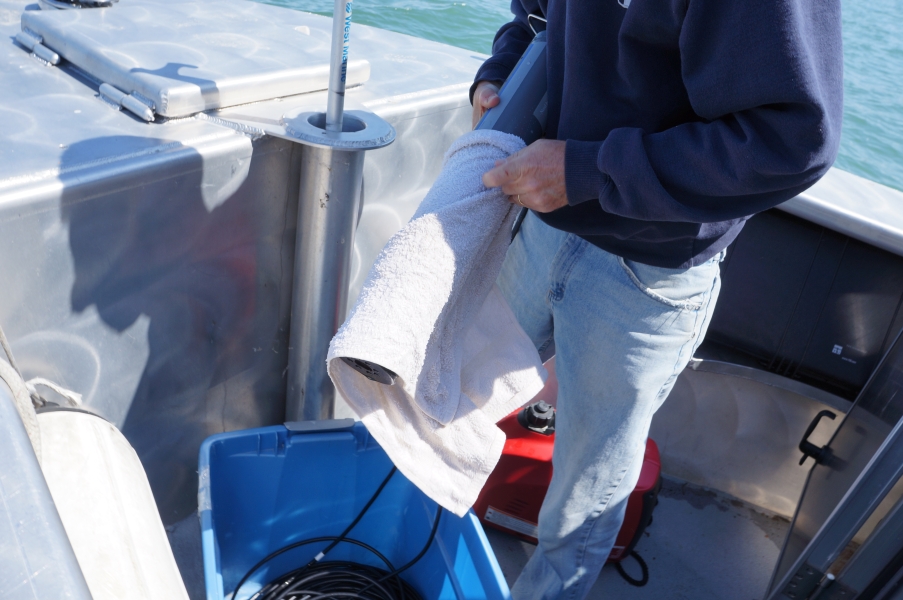 A person on a boat wrapping an instrument in a towel