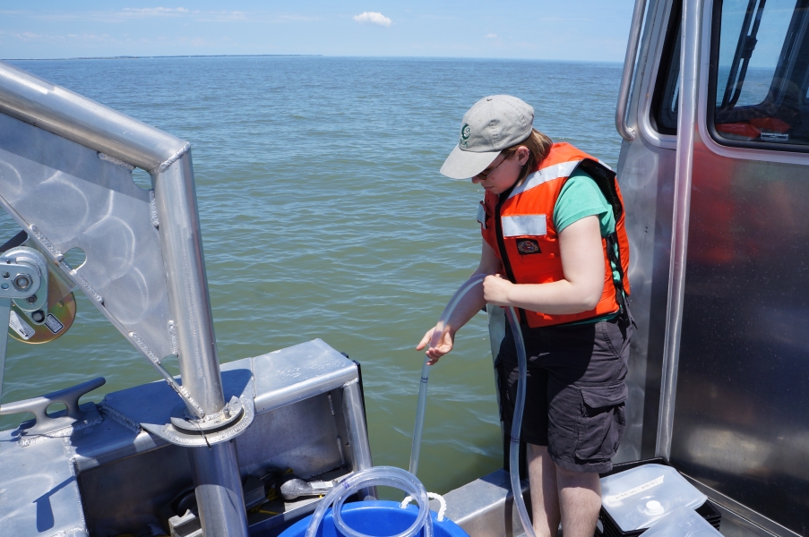 A person lowers a tube over the side of a boat