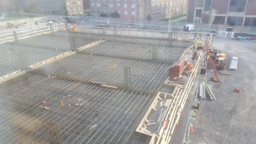 Rebar layed out in a grid on the second story of a building under construction.