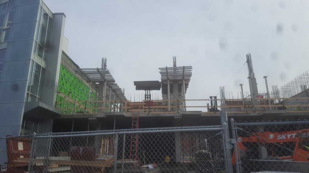 A building under construction. Struts are being put up on the second floor.