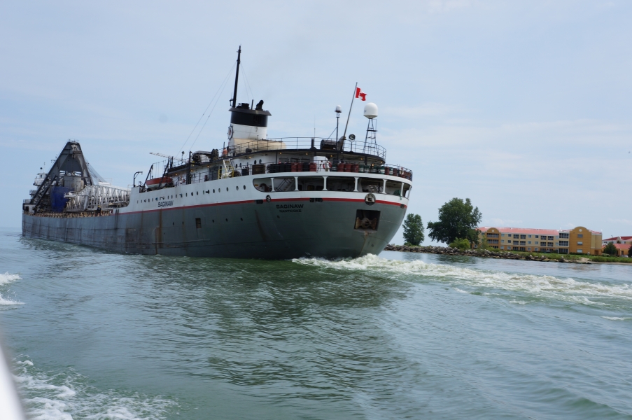 The back end of a very large and long boat near the shore