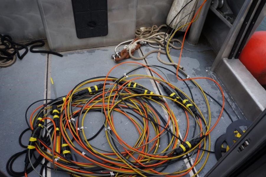 Cables lying coiled on the back deck of a boat.